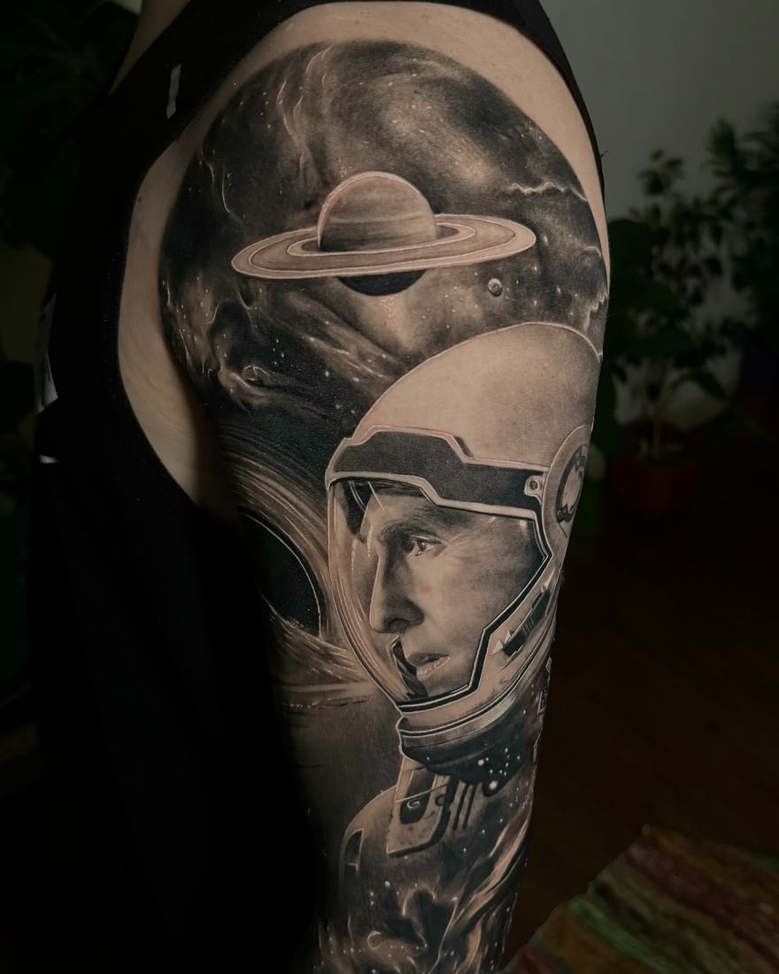 Tatuaje realismo black and grey astronauta y Saturno